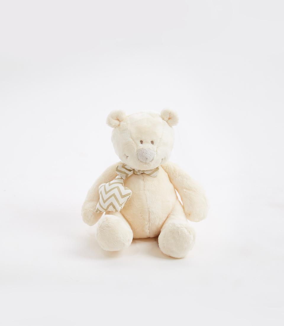 Soft cream-colored teddy bear with a chevron-patterned scarf around its neck on a white background.