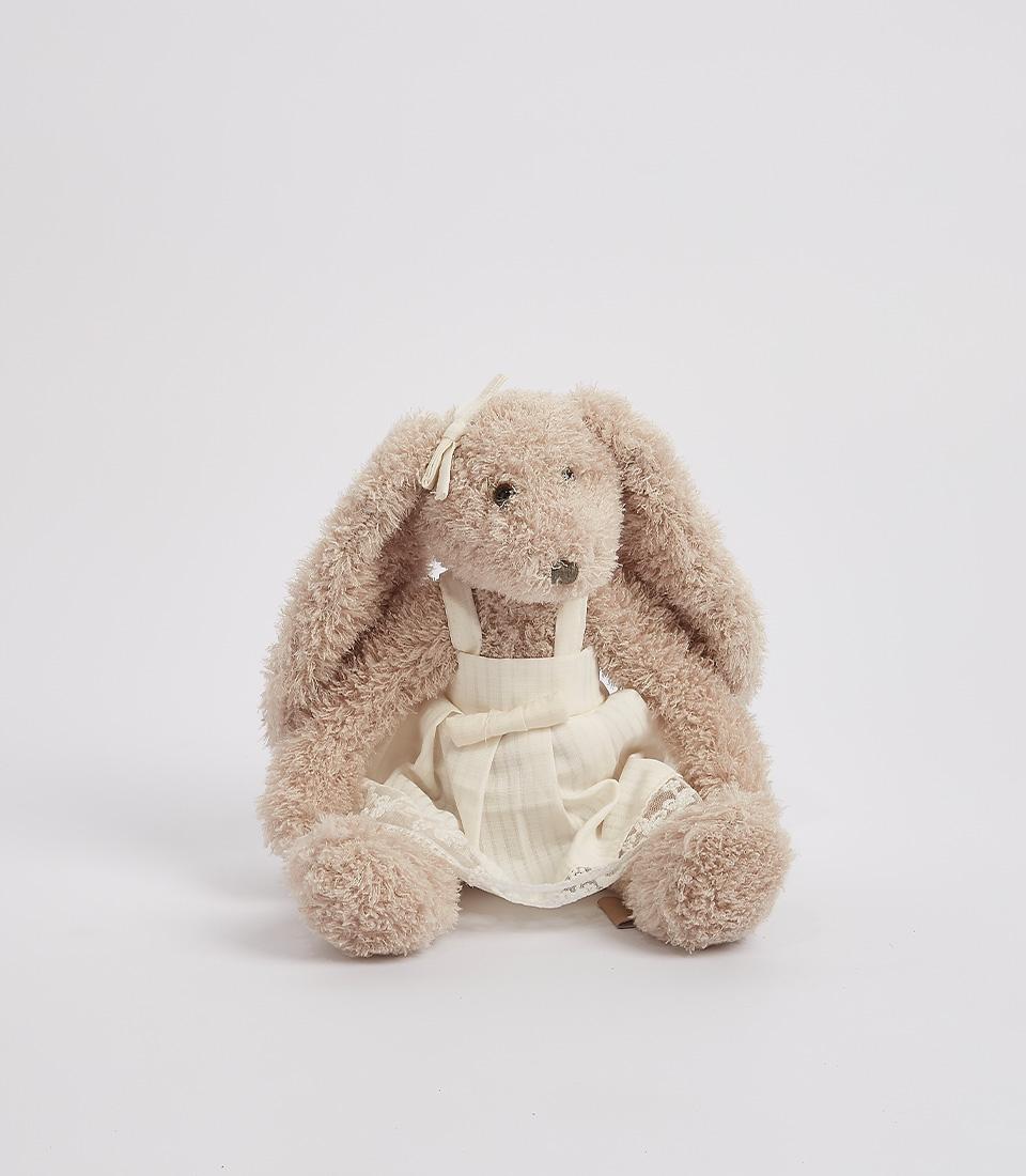 Gray plush bunny wearing a white dress with lace details, standing against a white background.