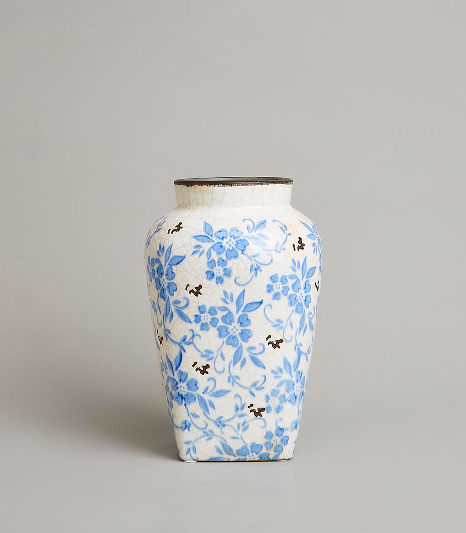 Vintage-style blue and white floral ceramic vase with intricate crackle glaze and square base on a light grey background.