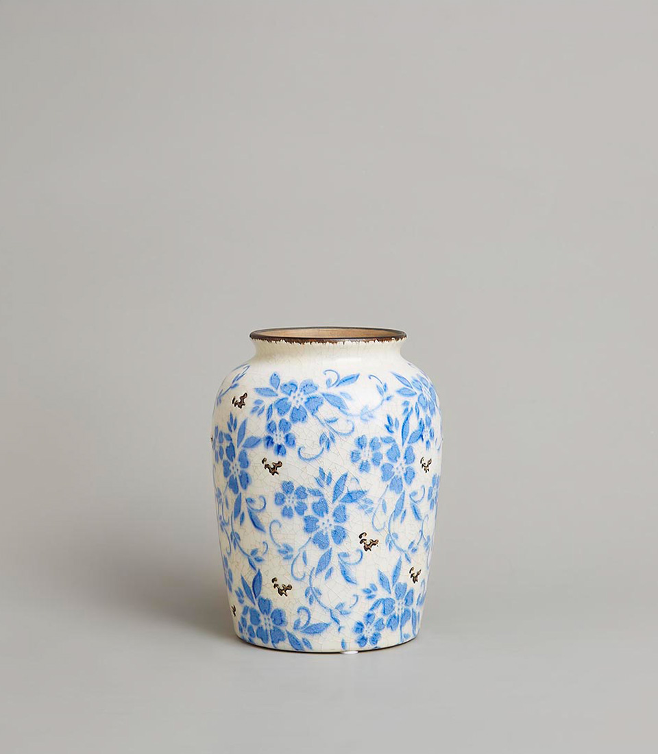 Vintage-style blue and white ceramic vase with an intricate floral pattern and delicate crackle glaze finish, on a light grey background