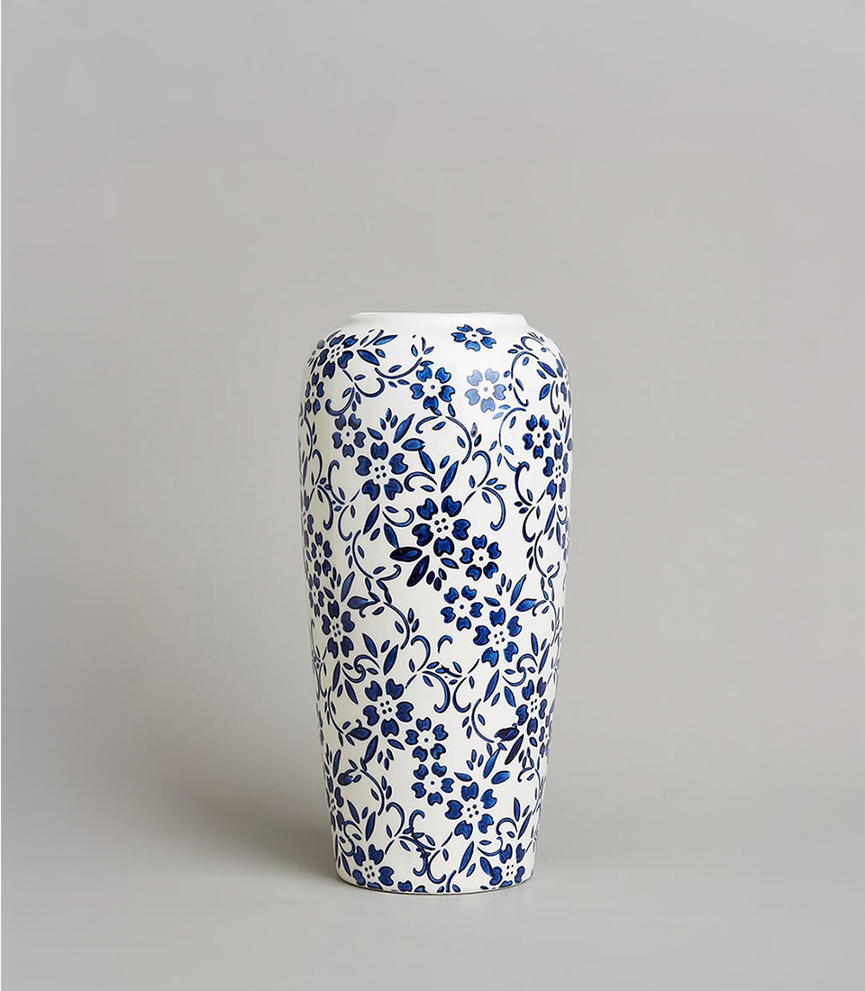 Blue and white floral ceramic vase with intricate flower and vine patterns on a light grey background
