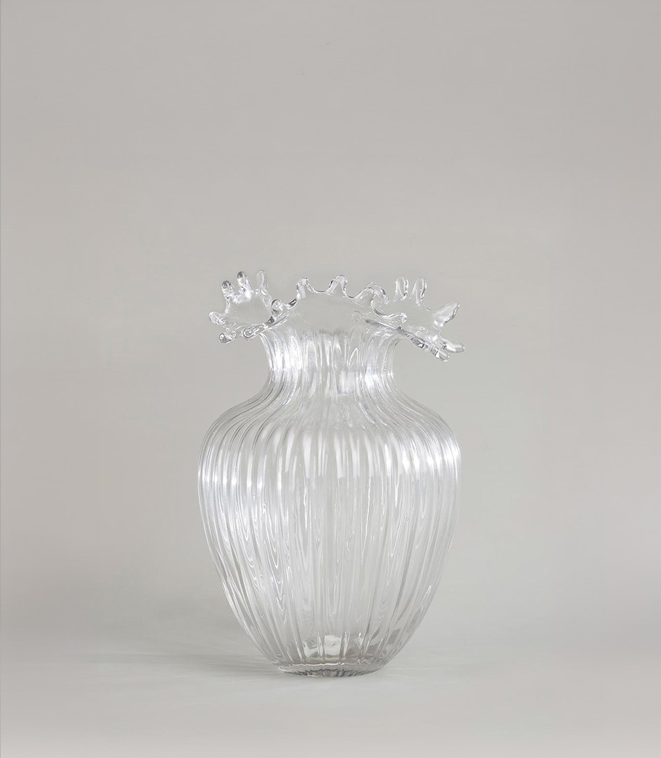 Elegant clear glass vase with a ribbed texture and wavy, ruffled rim, featuring a rounded body, on a light grey background.