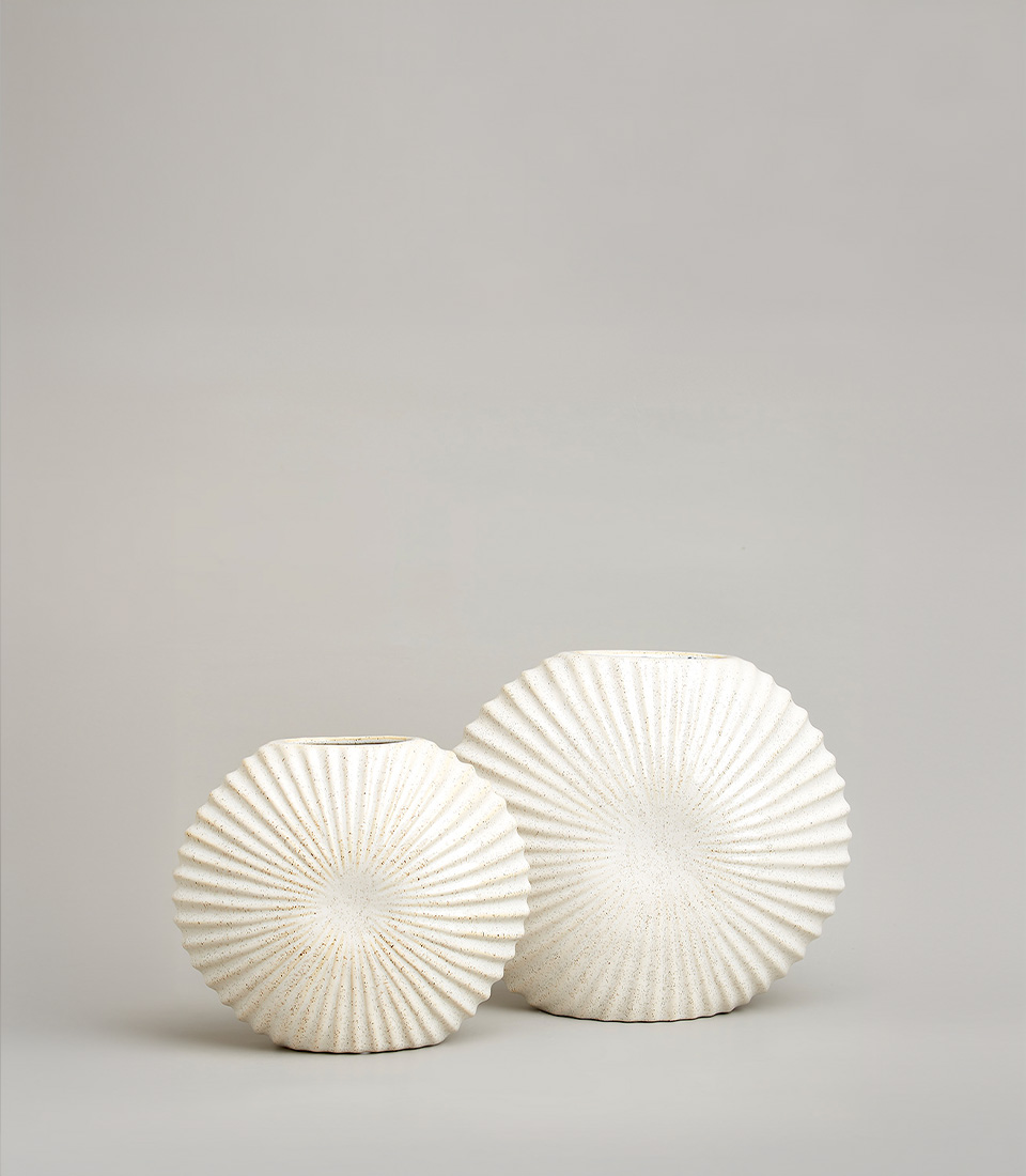 A set of two white ceramic vases featuring a distinctive radiating texture. The vases vary in size, adding a stylish and contemporary touch to any interior decor.A set of two white ceramic vases featuring a distinctive radiating texture. The vases vary in size, adding a stylish and contemporary touch to any interior decor.