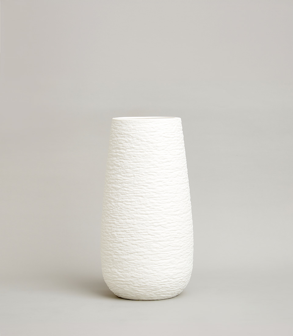 Minimalist tall white ceramic vase with a textured, pebble-like surface and a tapered cylindrical shape, on a light grey background.