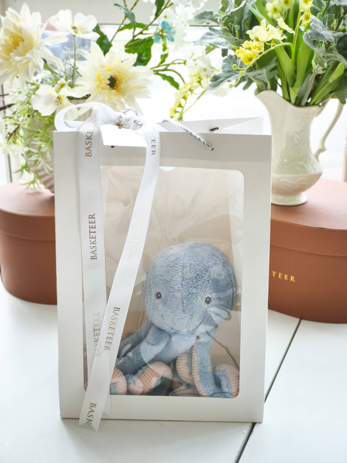 Plush blue octopus stuffed toy in a premium white gift box with ribbon