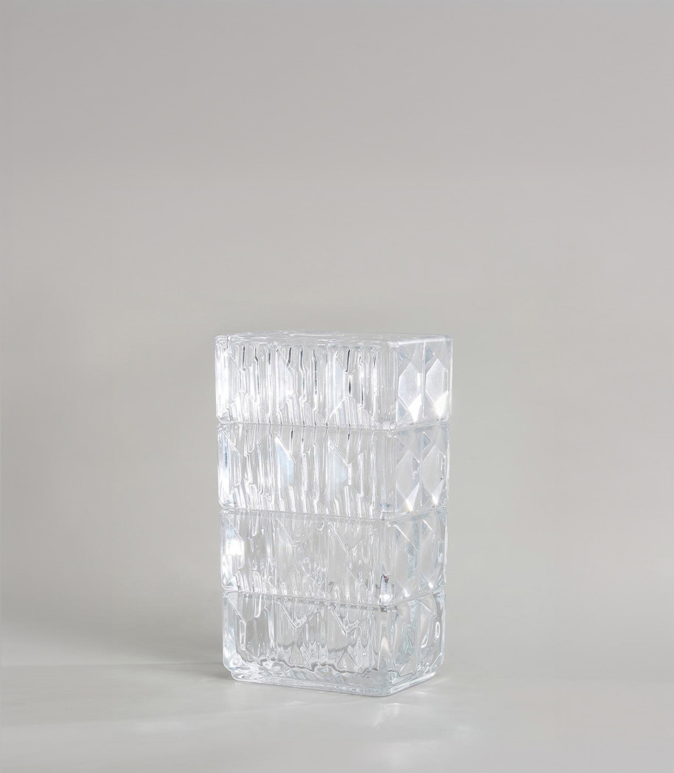 Modern clear glass vase with a geometric design, featuring rectangular shape and textured patterns, on a light grey background