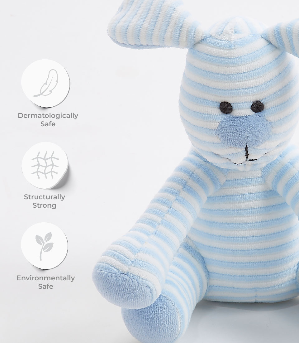 A striped, blue and white plush toy resembling a bunny is shown. Three symbols beside it represent that the toy is dermatologically safe, structurally strong, and environmentally safe. The blue striped puppy plush has large ears and black stitched eyes and nose.