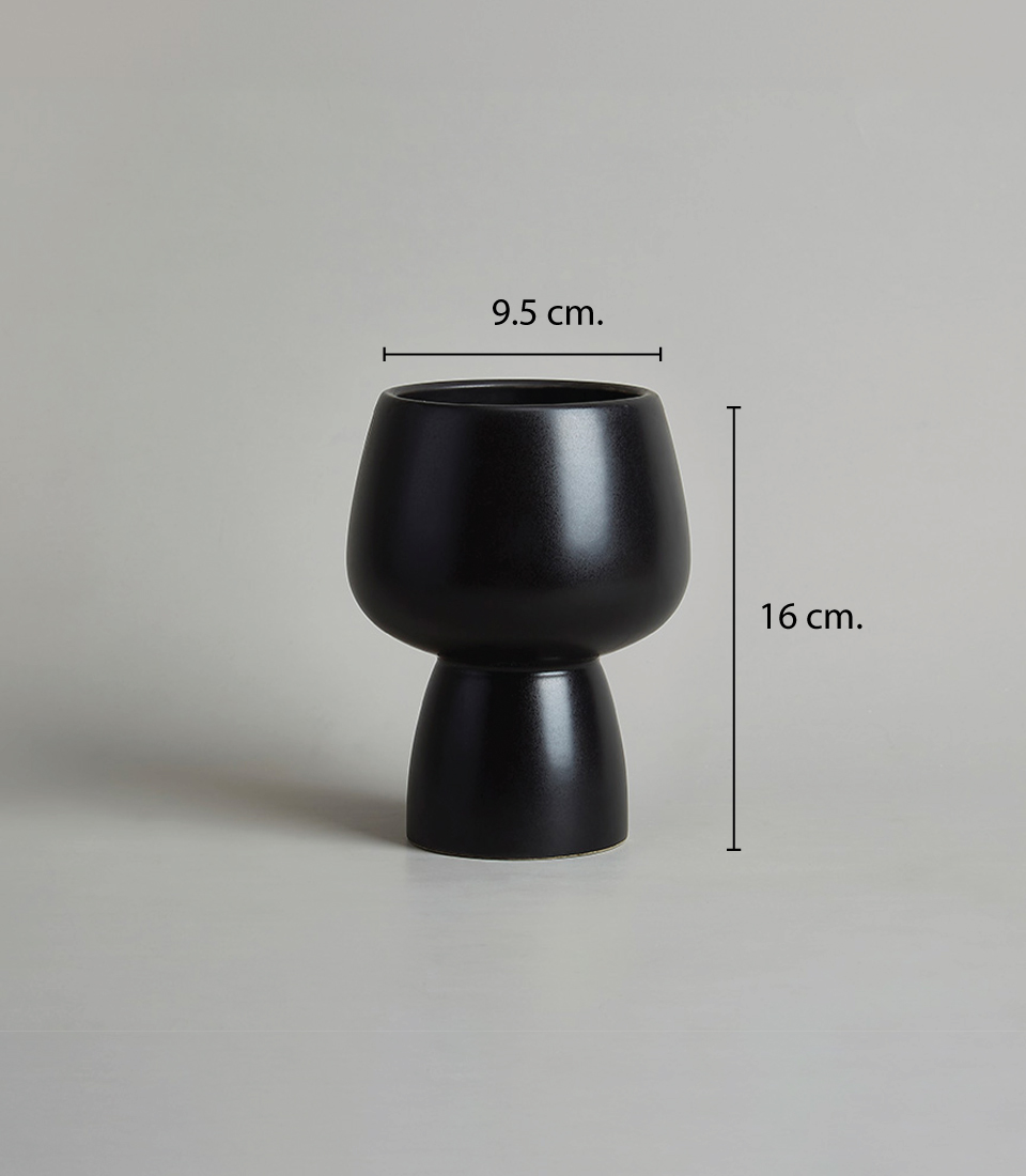 Black ceramic vase with a unique silhouette, measuring 9.5 cm in width and 16 cm in height.