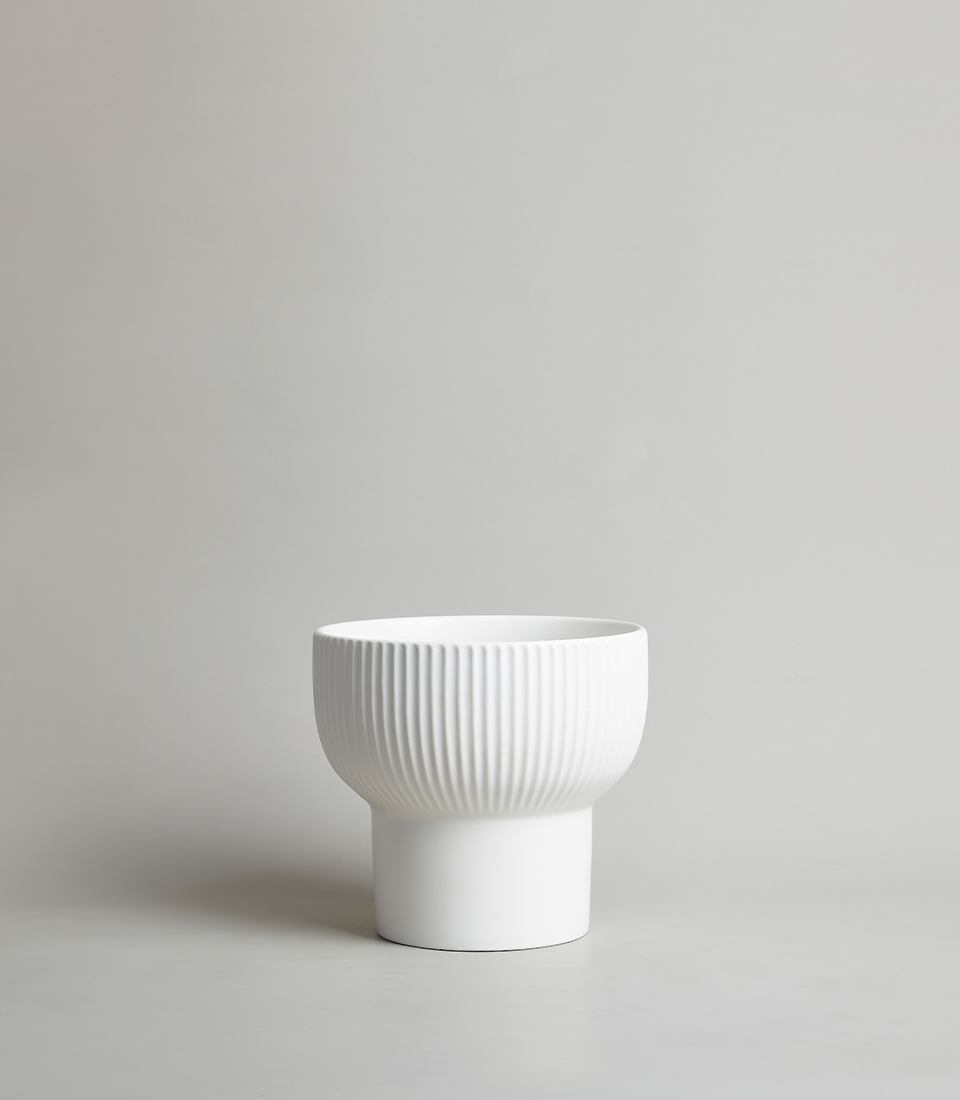 Modern White Ceramic Vase with Ribbed Design on a Grey Background.