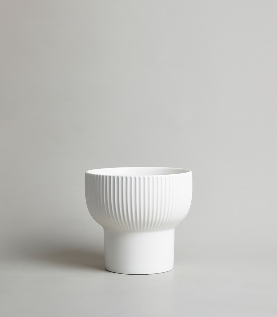 Modern White Ceramic Vase with Ribbed Design on a Grey Background.