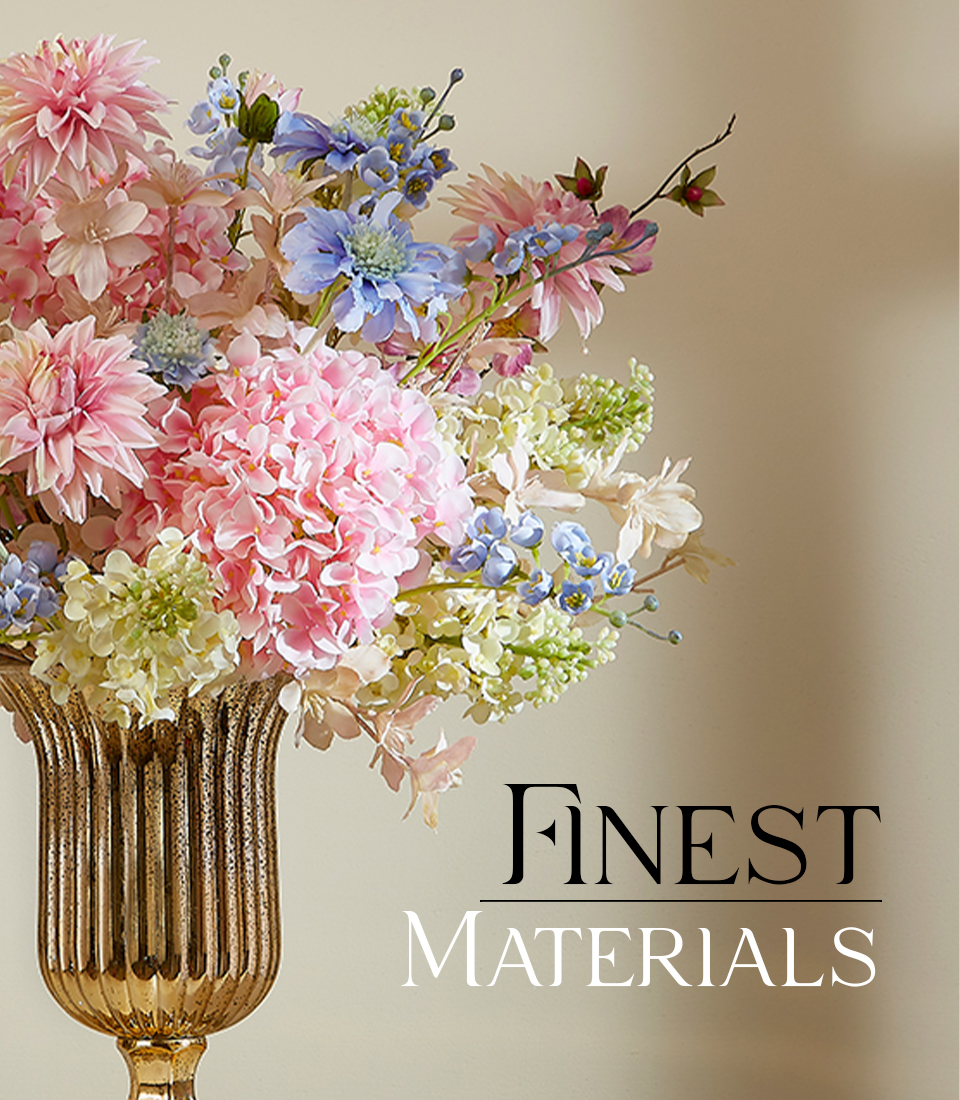 Artificial flower arrangement with pink hydrangeas and blue delphiniums in a gold vase with 