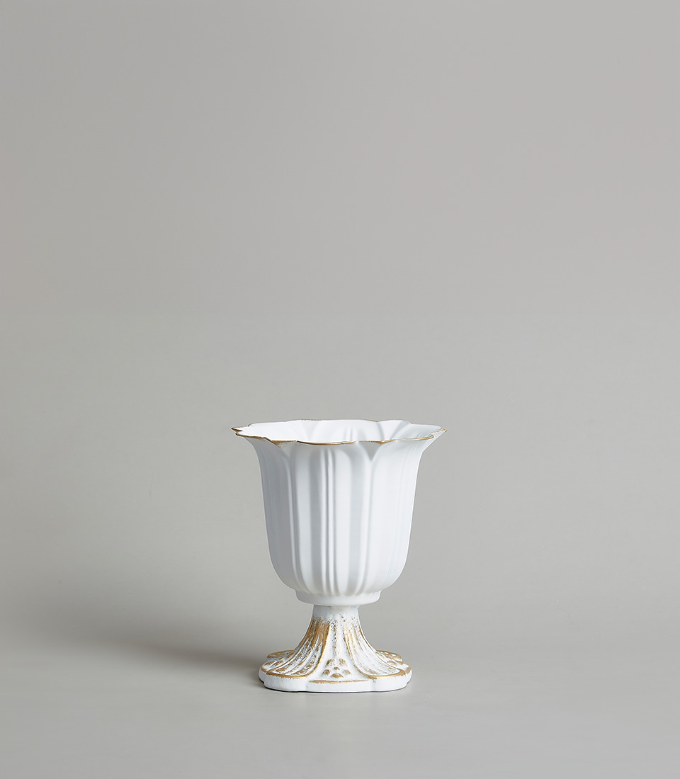 Elegant stainless steel vase with gold detailing and a classic pedestal design, on a light grey background.