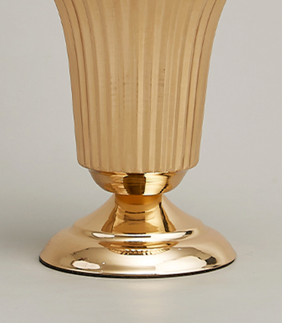 Close-up view of the base of a gold-plated stainless steel vase with a modern fluted design.