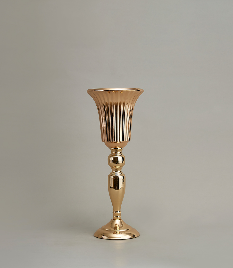 Elegant gold-plated stainless steel vase with a tall profile and fluted design, on a light grey background.