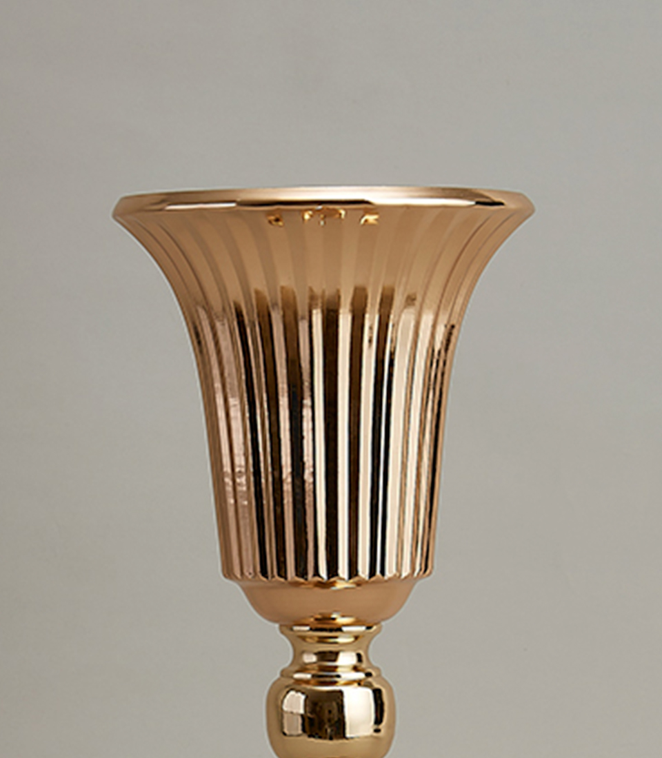 Close-up of a luxurious gold-plated stainless steel vase with a tall, elegant profile and fluted design.