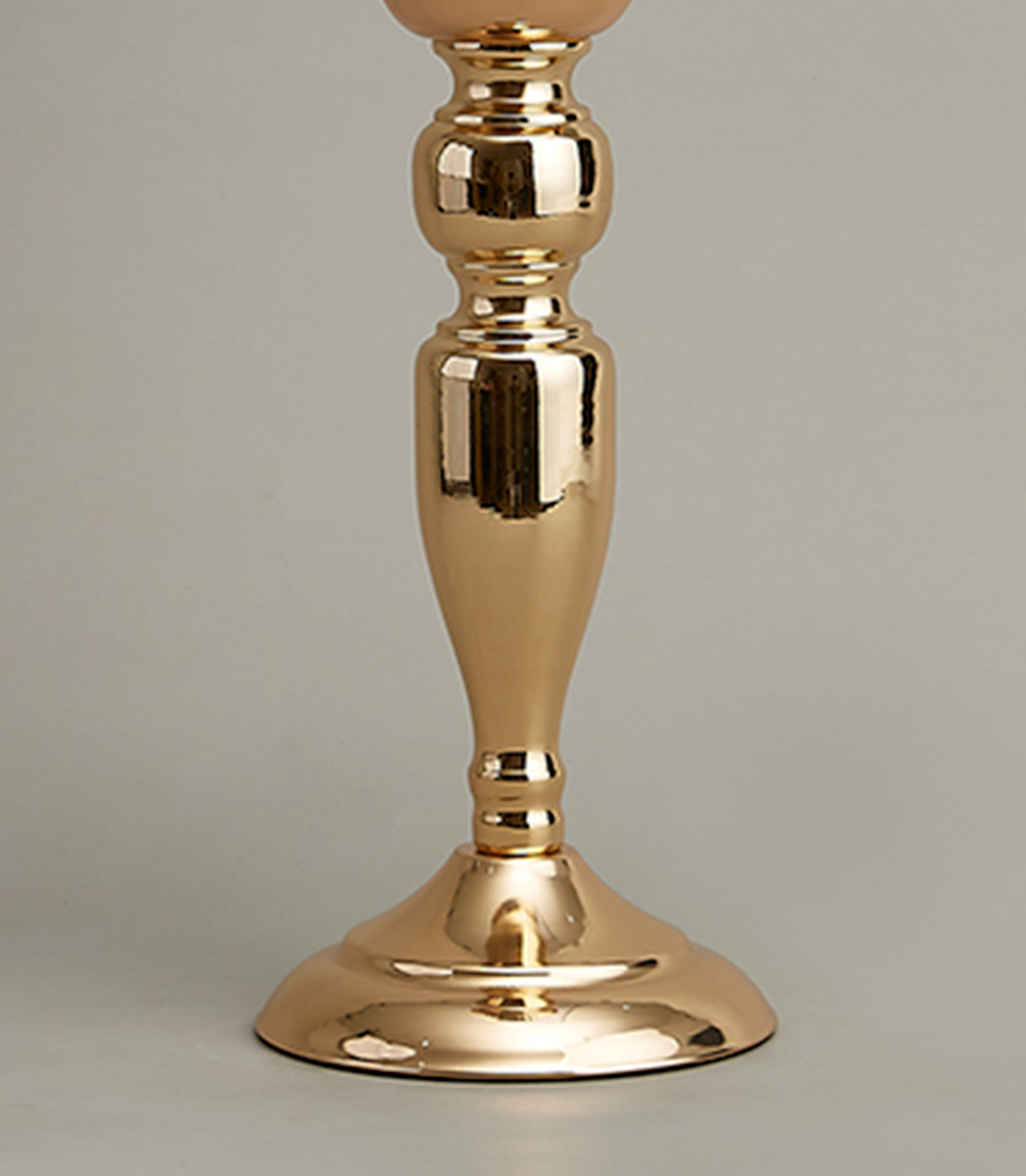 Close-up of a luxurious gold-plated stainless steel vase with a tall, elegant profile and fluted design.