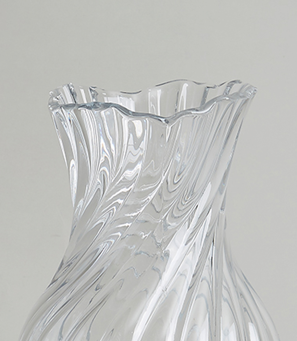 Close-up of Elegant crystal vase with a swirl design on a white background.