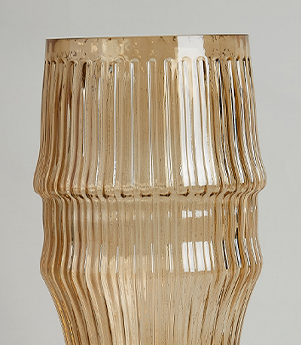 Close-up of Elegant amber glass vase with a ribbed texture on a white background.