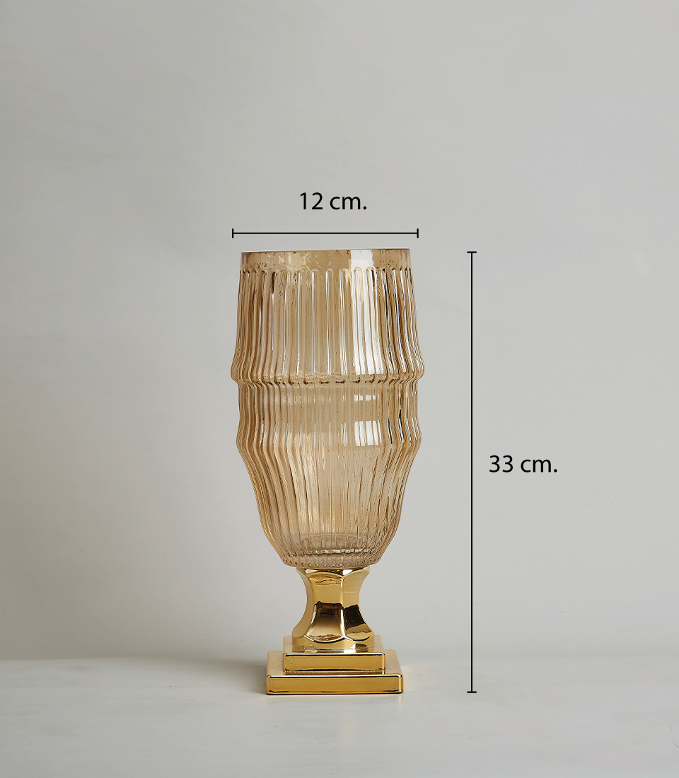 Elegant amber glass vase with a ribbed texture and gold base, 33 cm. tall and 12 cm. wide, on a white background.