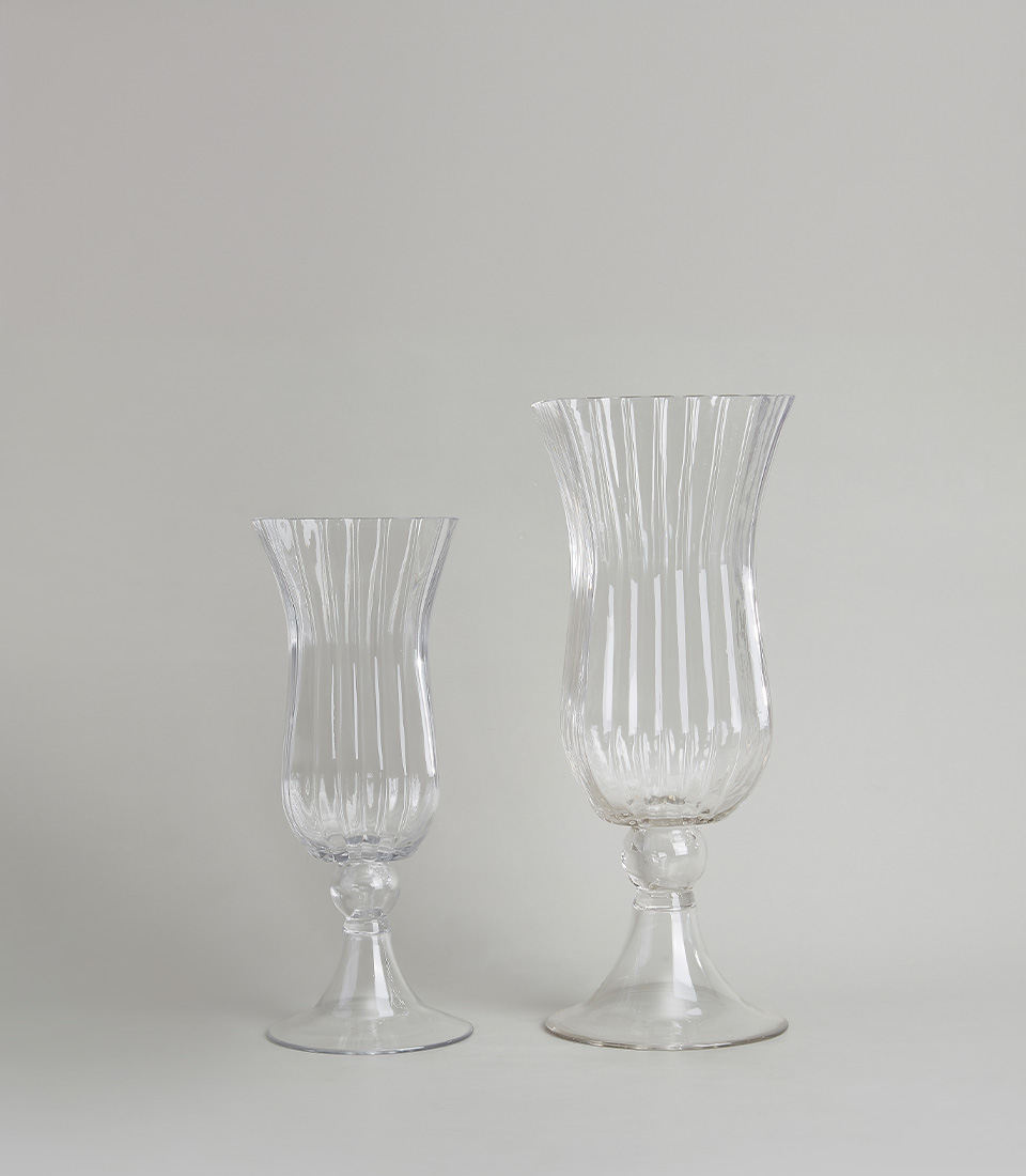 Set of two elegant ribbed glass vases with fluted designs, on a white background.