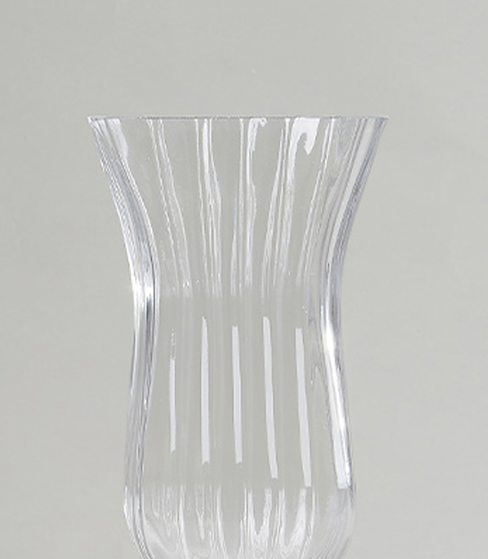 Close-up of an elegant ribbed glass vase with a fluted design.