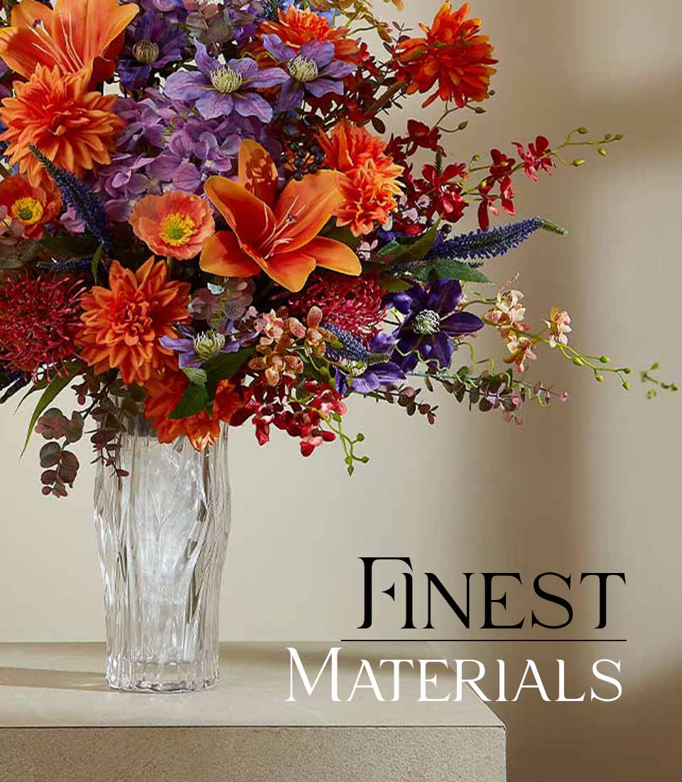 Elegant artificial flower arrangement in a clear textured vase with vibrant orange and purple flowers, featuring the text 