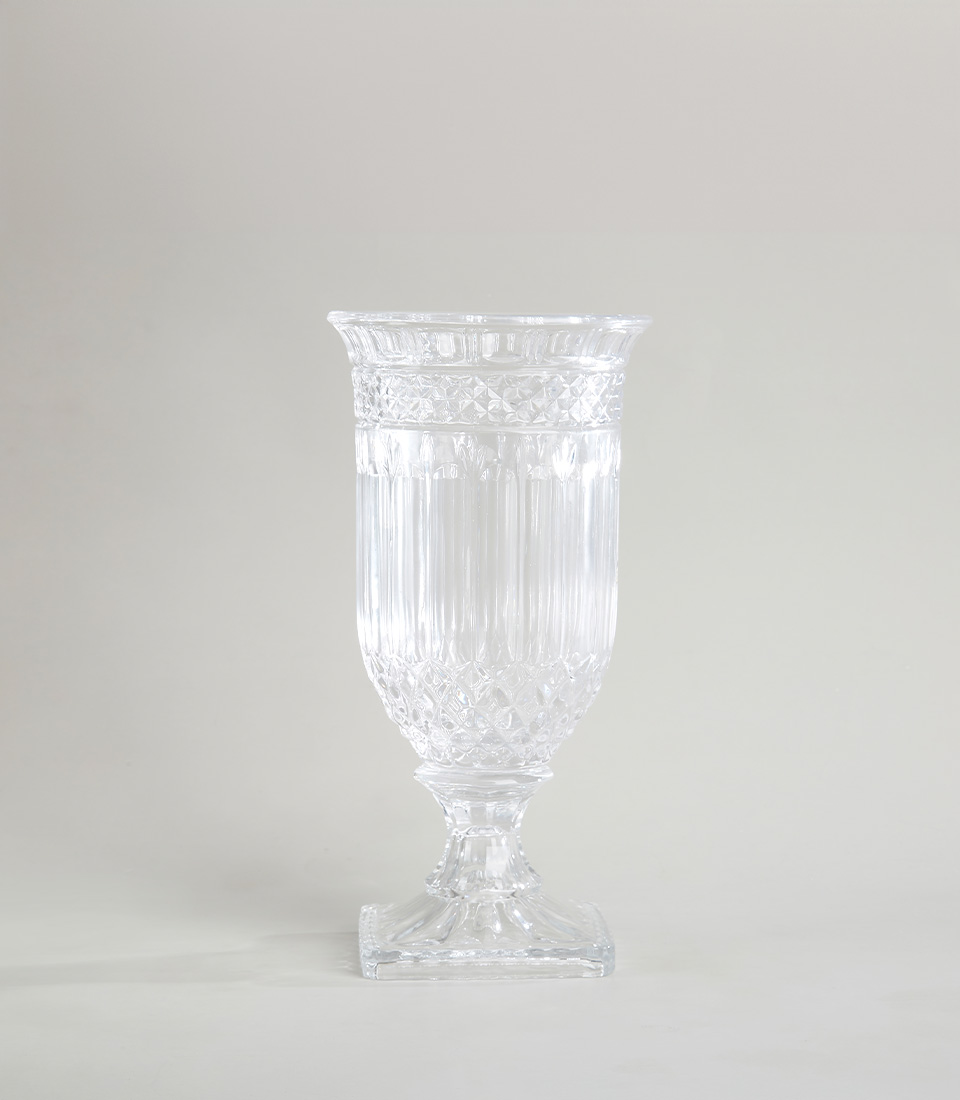 Elegant tall crystal vase with intricate diamond and vertical stripe pattern on a square pedestal base, on a light gray background.