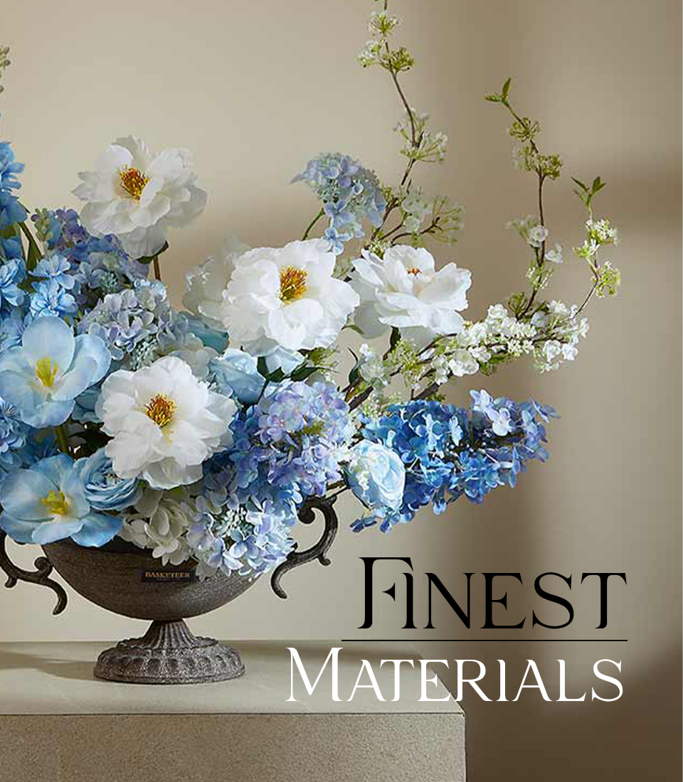 Artificial blue and white floral arrangement in an ornate pedestal vase on a beige table with text 