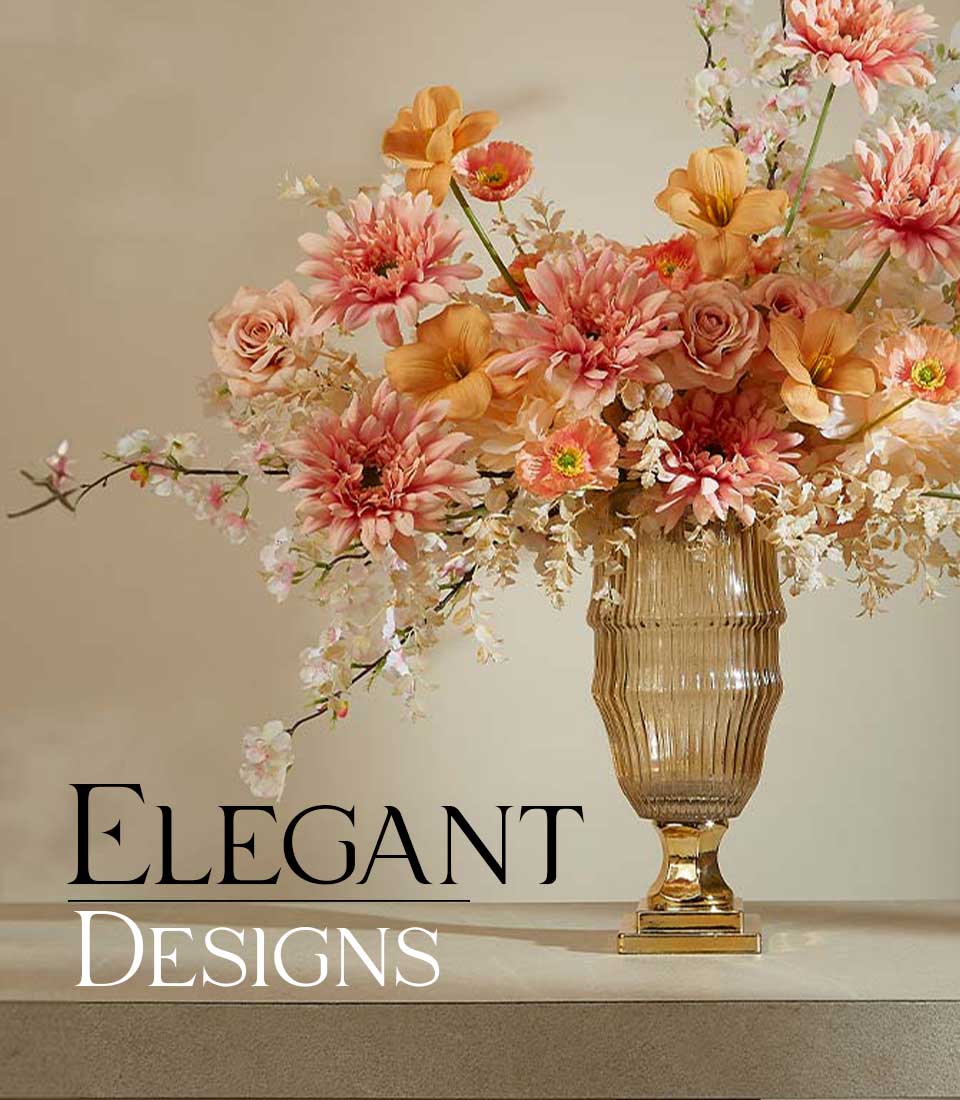 Artificial flower arrangement with soft peach dahlias, creamy orchids, and delicate roses in a tall gold vase on a table, displayed on a beige background with text 