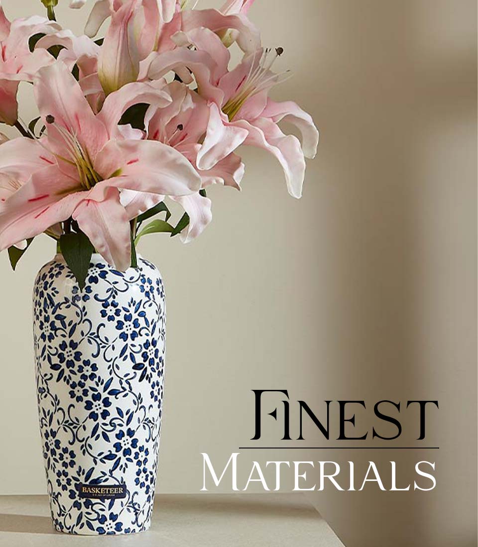 Artificial pink lilies in a blue and white ceramic vase on a table with text 