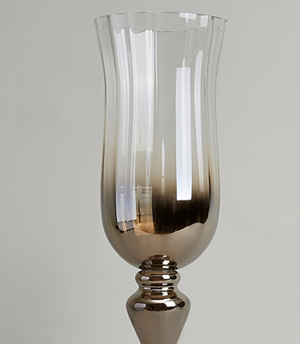 Close-up view of a tall ombre silver glass vase with a pedestal base, highlighting the sleek reflective finish and smoky gradient.