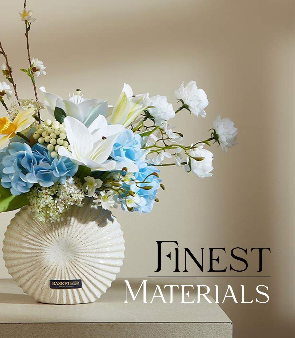 Close-up of artificial flower arrangement with white lilies, blue hydrangeas, and yellow daffodils in a white ceramic vase and 