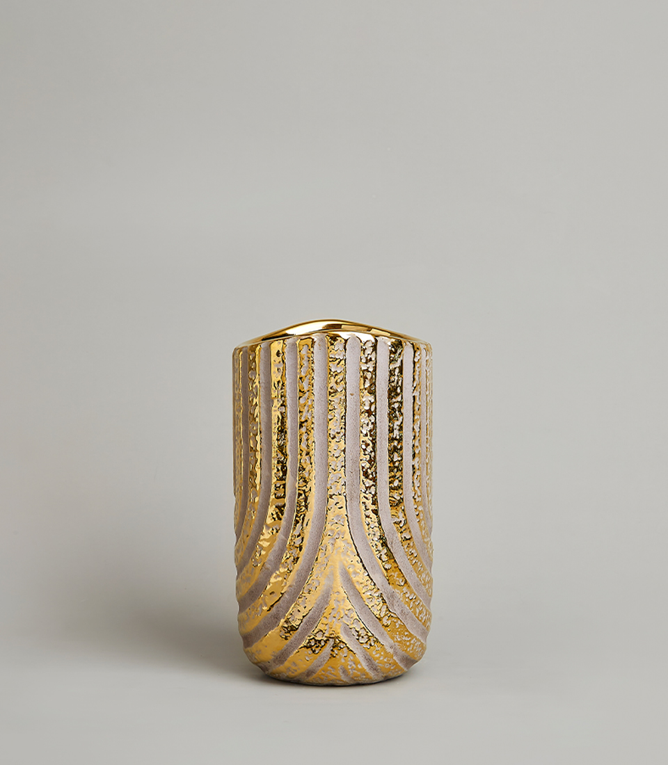Elegant gold textured vase with intricate patterns on a light gray background.