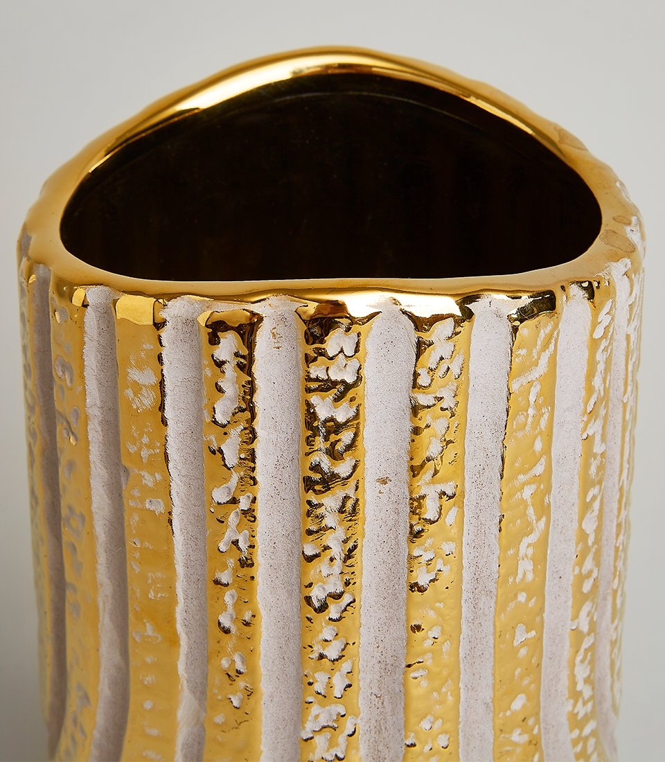Close-up view of a gold textured vase with intricate vertical patterns and a luxurious finish.