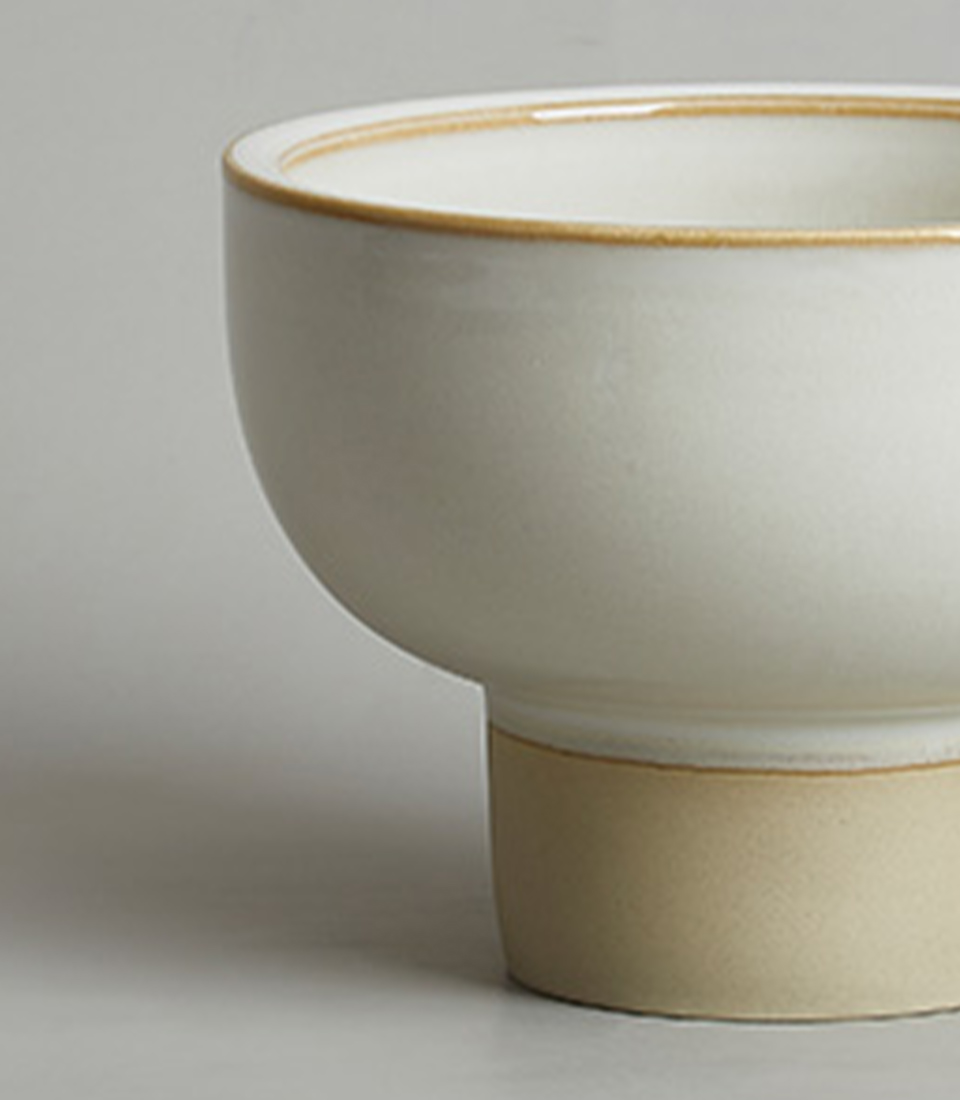 Close-up of minimalist white ceramic pedestal bowl vase.