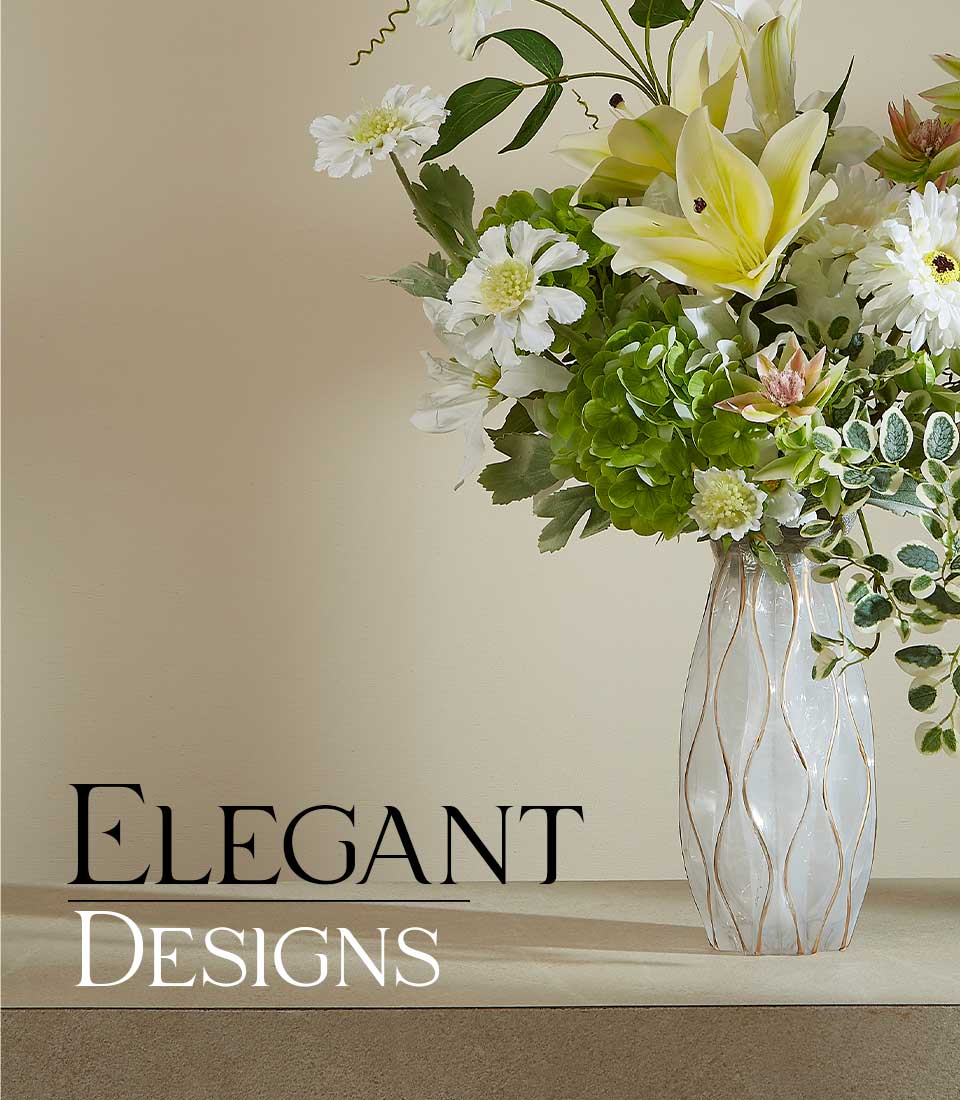 Close-up of an Artificial flower arrangement featuring white lilies, daisies, green hydrangeas, and foliage in a modern textured vase, with a 