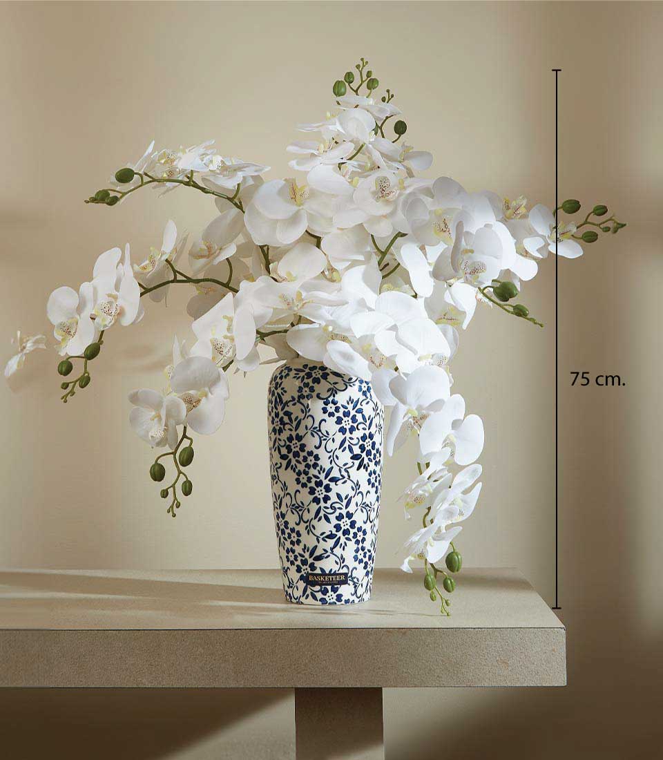 Artificial white orchids in a blue and white ceramic vase with floral patterns on a table, displayed on a beige background, featuring a height measurement of 50 cm.