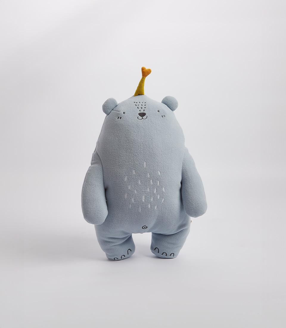A charming blue bear plush toy wearing a small yellow party hat, on a white background.