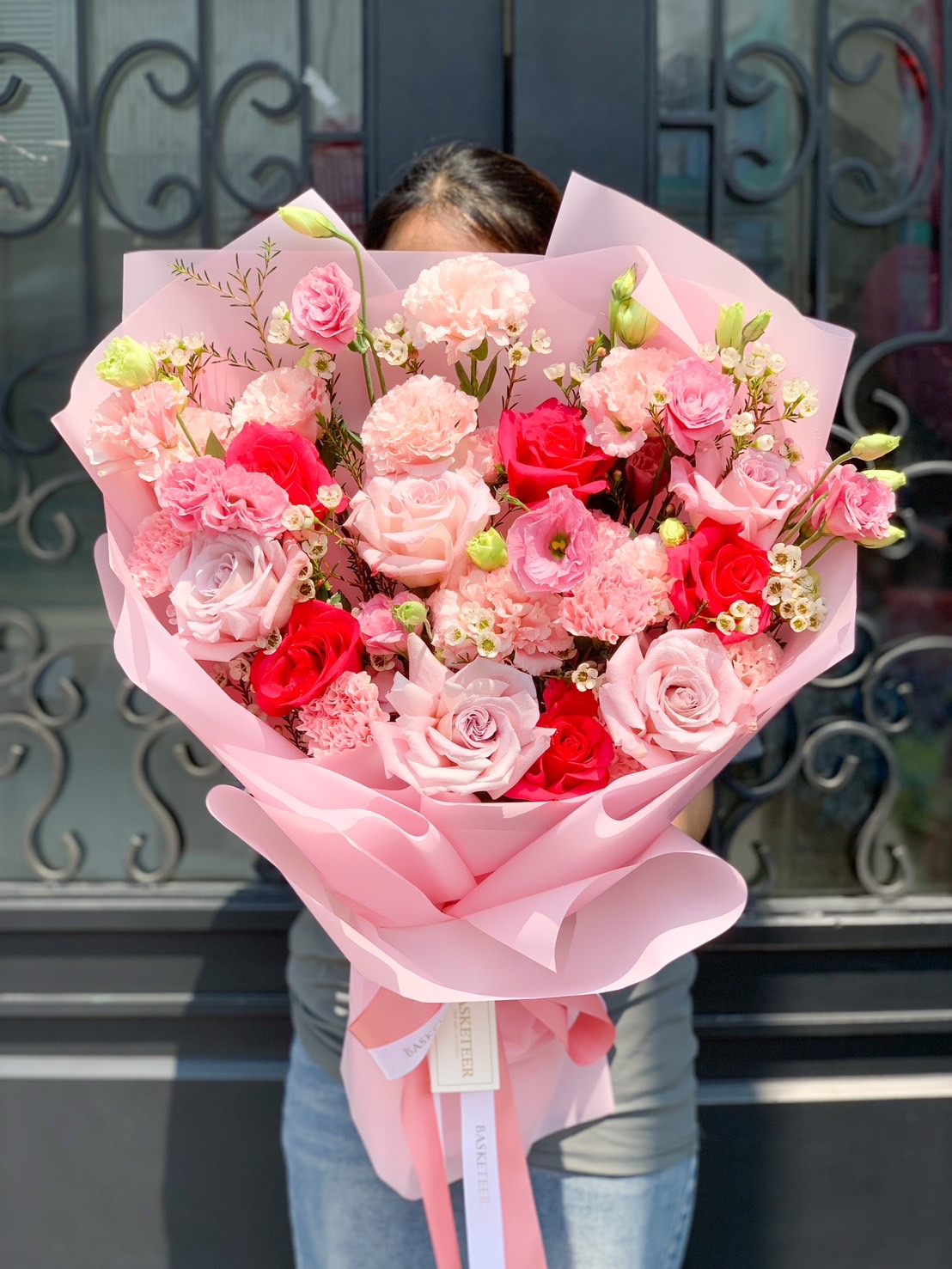 A luxurious pink & red rose bouquet wrapped in soft blush paper, featuring roses, carnations, lisianthus, and baby’s breath, perfect for romantic gifts & special occasions.