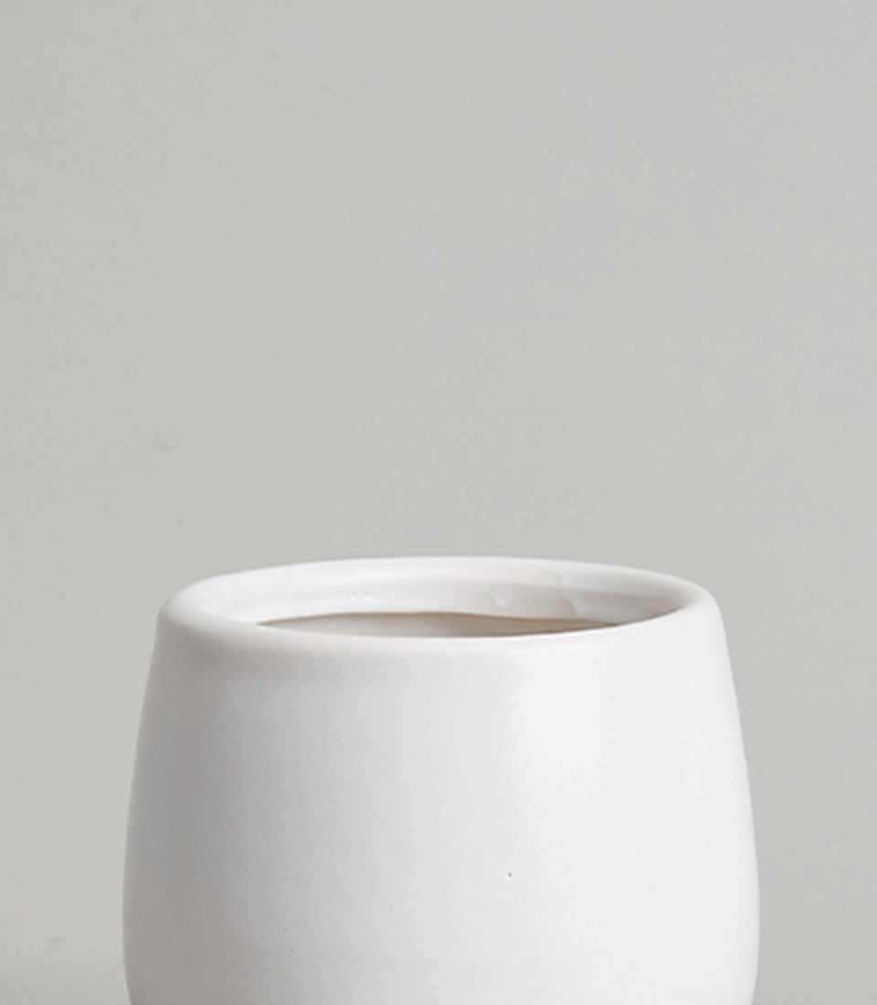 Close-up of a white ceramic vase with a smooth, cylindrical design.