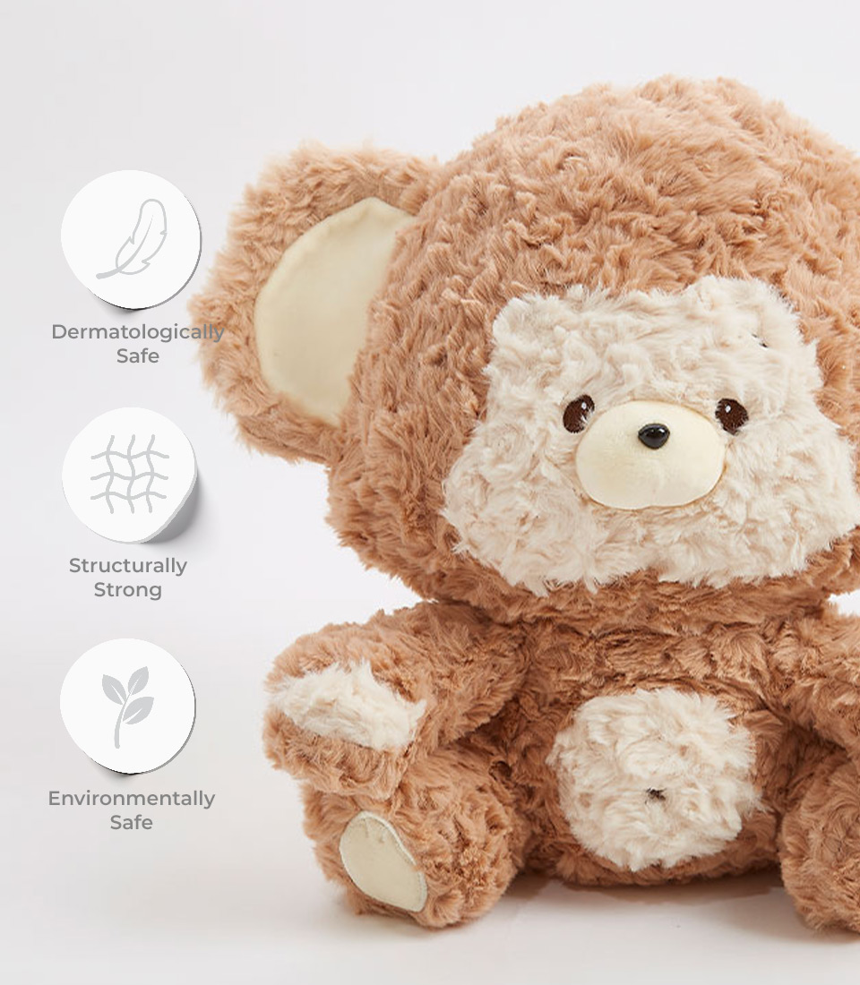 Cute brown teddy bear plush toy with a white snout and belly, featuring labels for being dermatologically safe, structurally strong, and environmentally safe