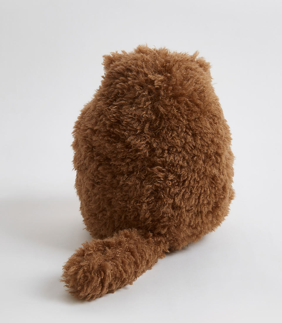 Back view of a shaggy brown bear plush toy with a fluffy tail.