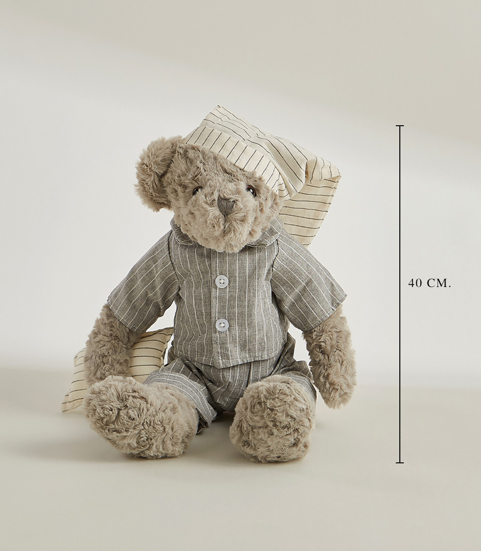 A grey teddy bear wearing striped pajamas and a matching nightcap, standing and ready for bedtime, set against a light gray background.
