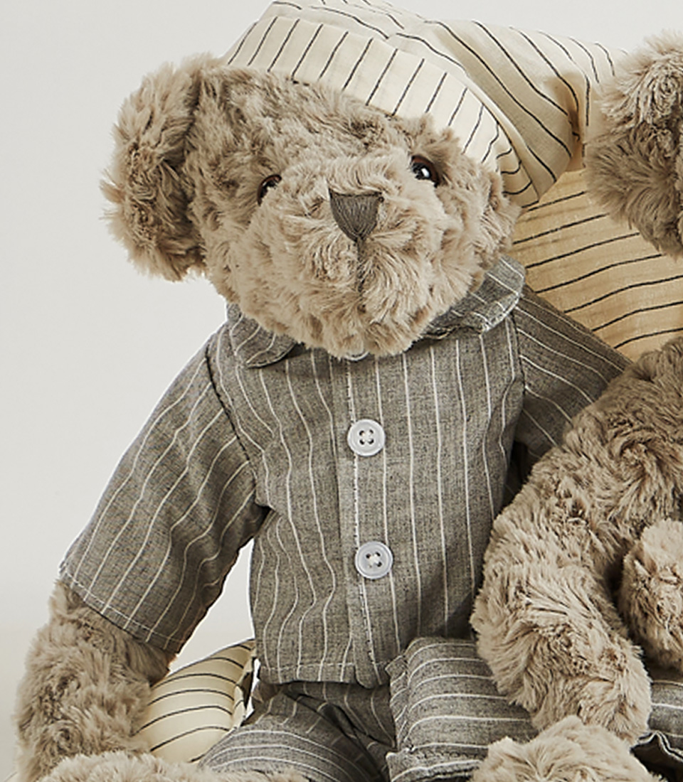 A set of two grey teddy bears dressed in matching striped pajamas and nightgowns, complete with nightcaps, set against a light gray background.