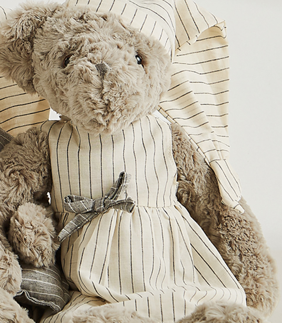 A set of two grey teddy bears dressed in matching striped pajamas and nightgowns, complete with nightcaps, set against a light gray background.