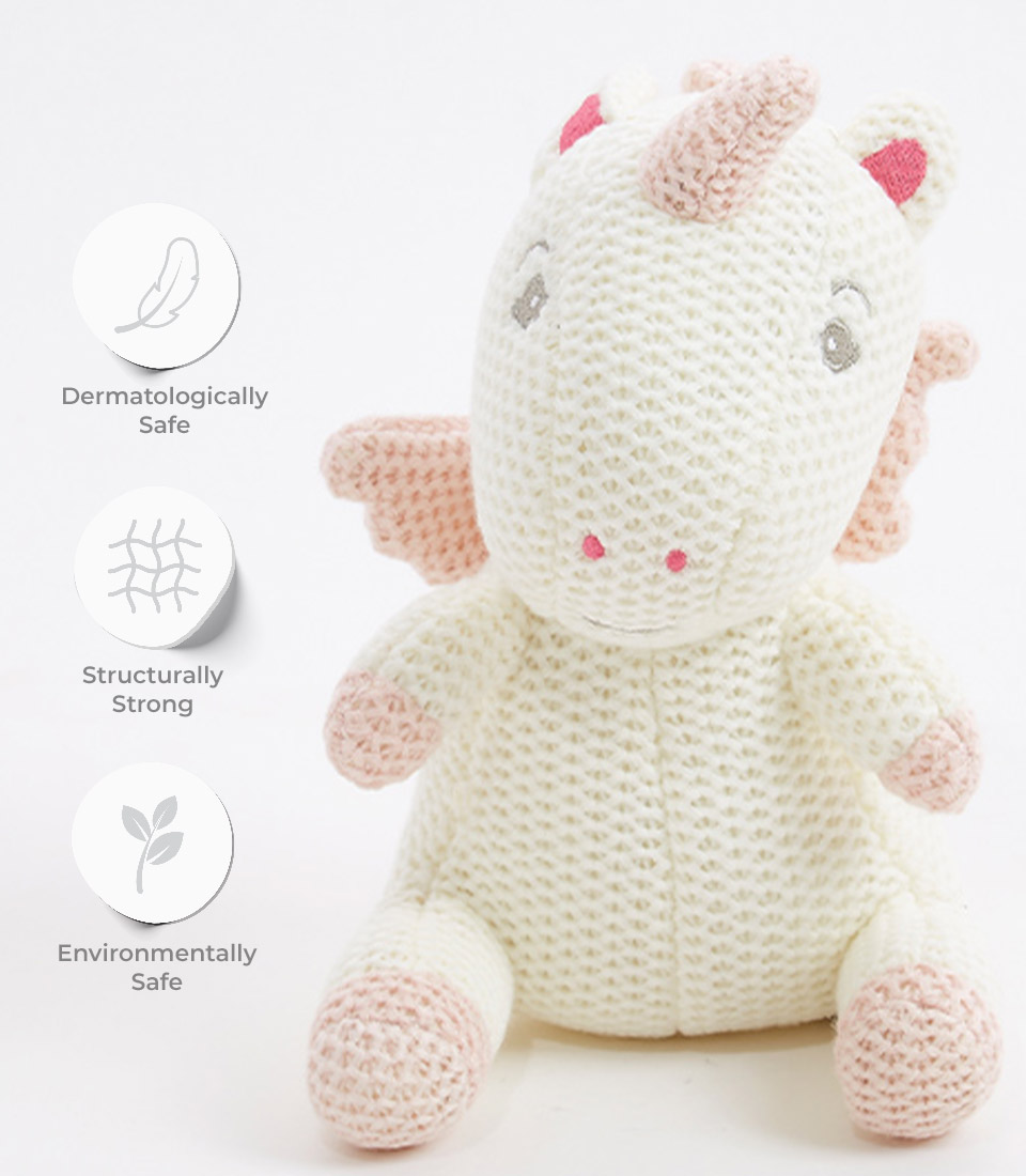 Handcrafted crocheted unicorn plush toy with a soft cream exterior, pastel pink accents on the hooves, mane, and tail, and a friendly face with embroidered eyes. The toy is dermatologically safe, structurally strong, and environmentally friendly, making it perfect for newborns and young children