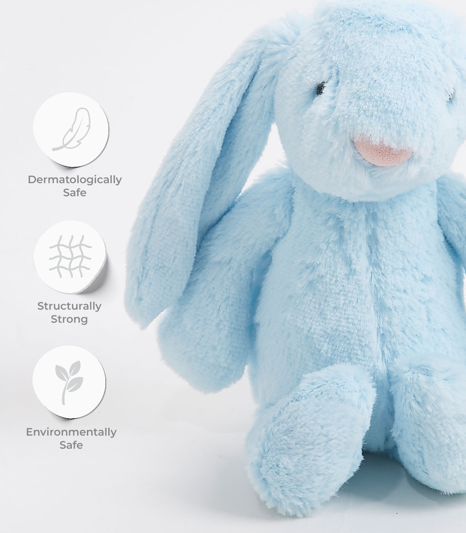 Close-up of a soft blue plush bunny toy with long floppy ears and an embroidered face, labeled as dermatologically safe, structurally strong, and environmentally safe.