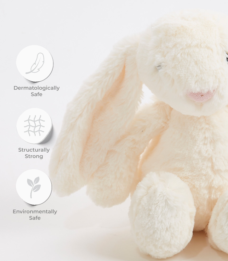 Close-up of a soft cream plush bunny toy with long floppy ears and an embroidered face, labeled as dermatologically safe, structurally strong, and environmentally safe