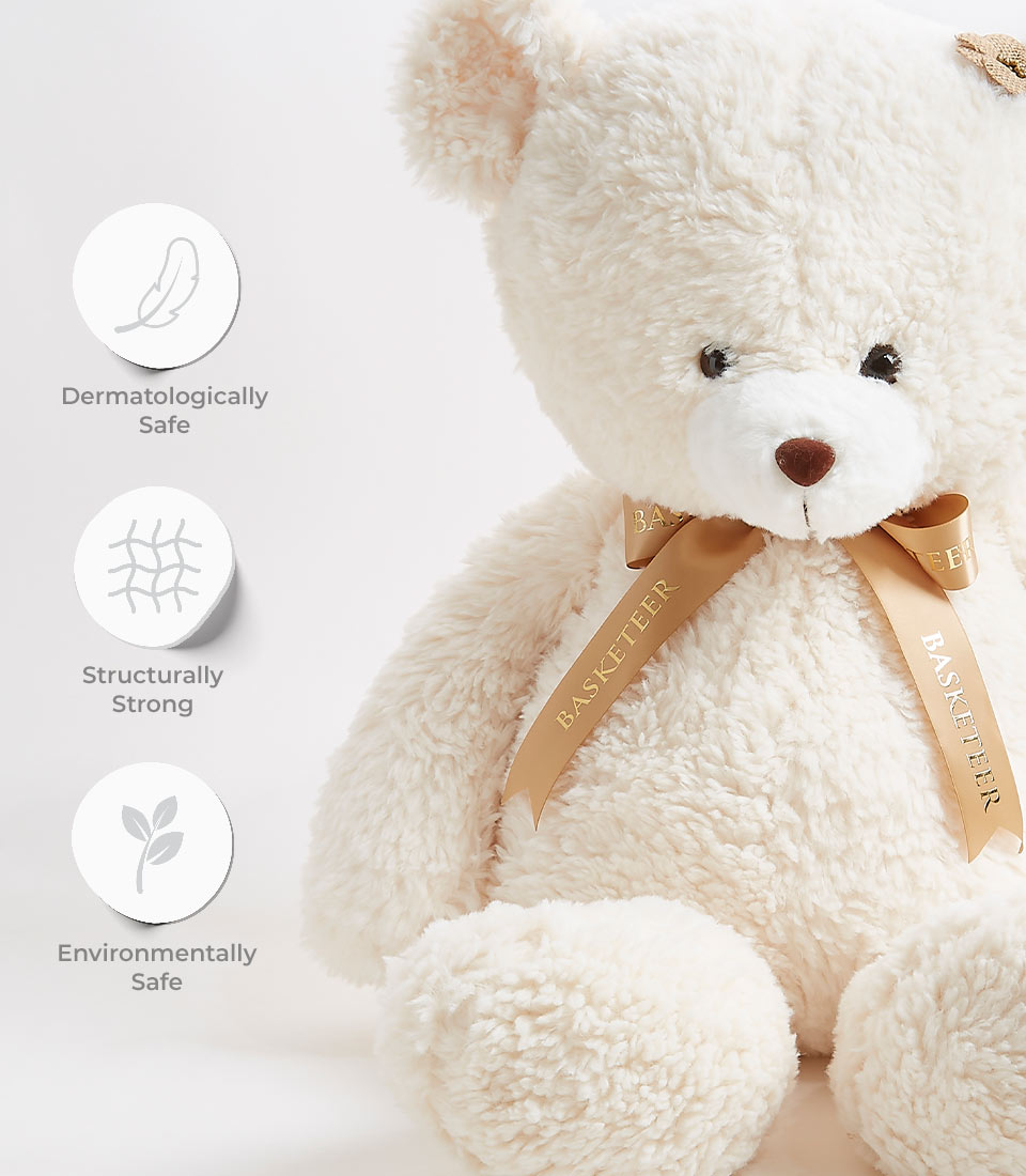 A large, plush teddy bear with cream-colored fur and a beige ribbon around its neck. The ribbon reads 