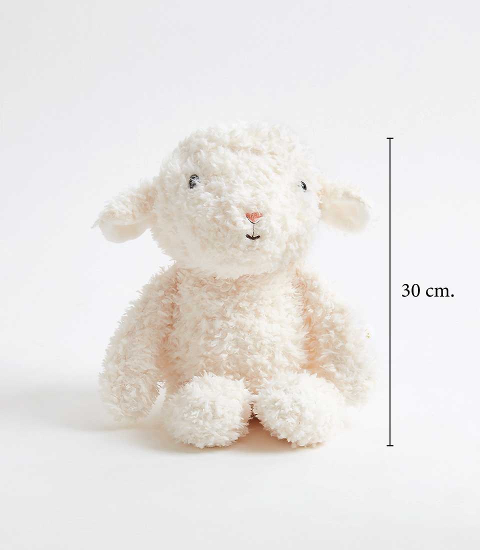A fluffy, white stuffed animal resembling a lamb sits upright against a plain background. The lamb has small black eyes and a simple embroidered smile. A vertical line on the right side marks the height of the toy as 30 cm.
